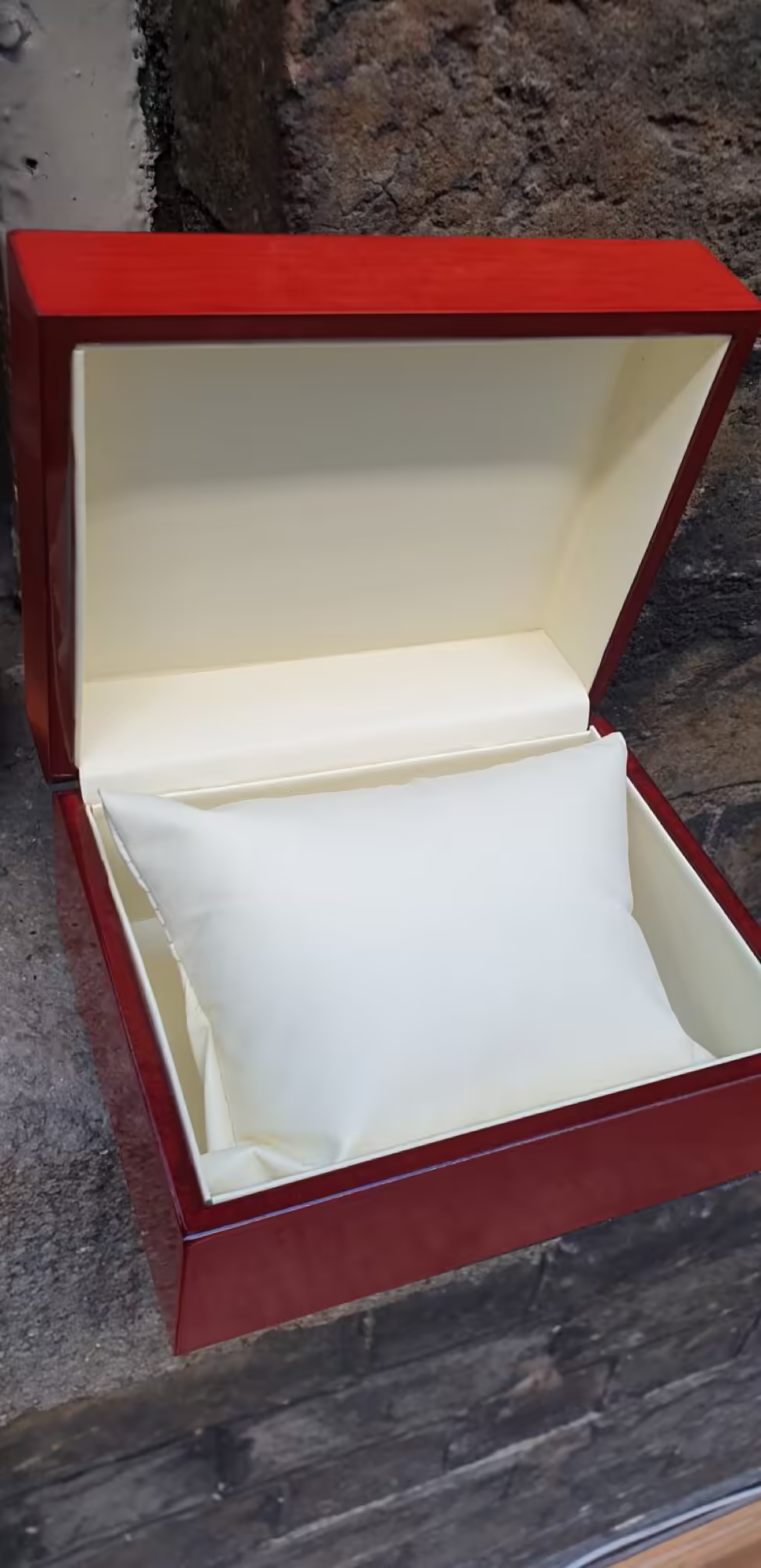 A lacquered watch display box with a cushion